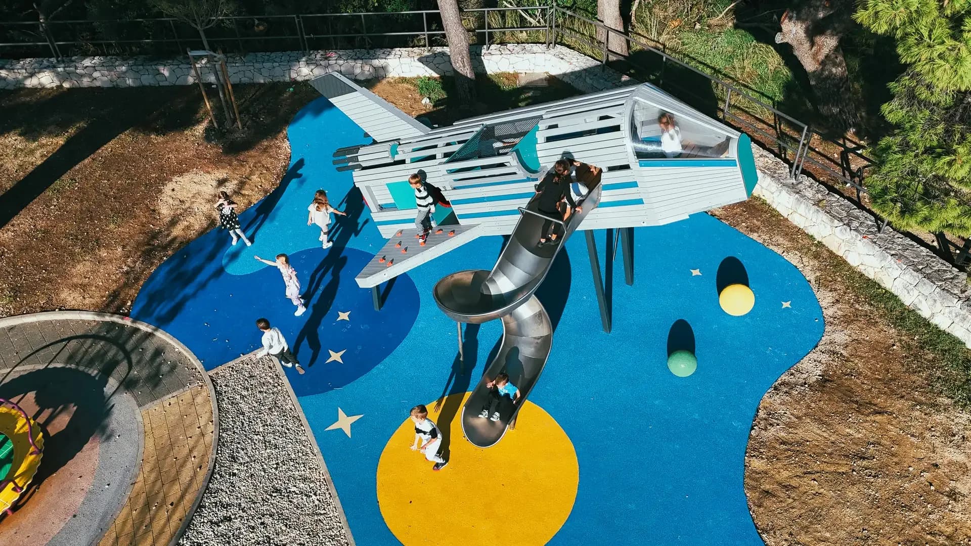 Aerial view of the space-themed rubber safety surfacing at Makarska Observatory, with planets, stars and orbital paths.