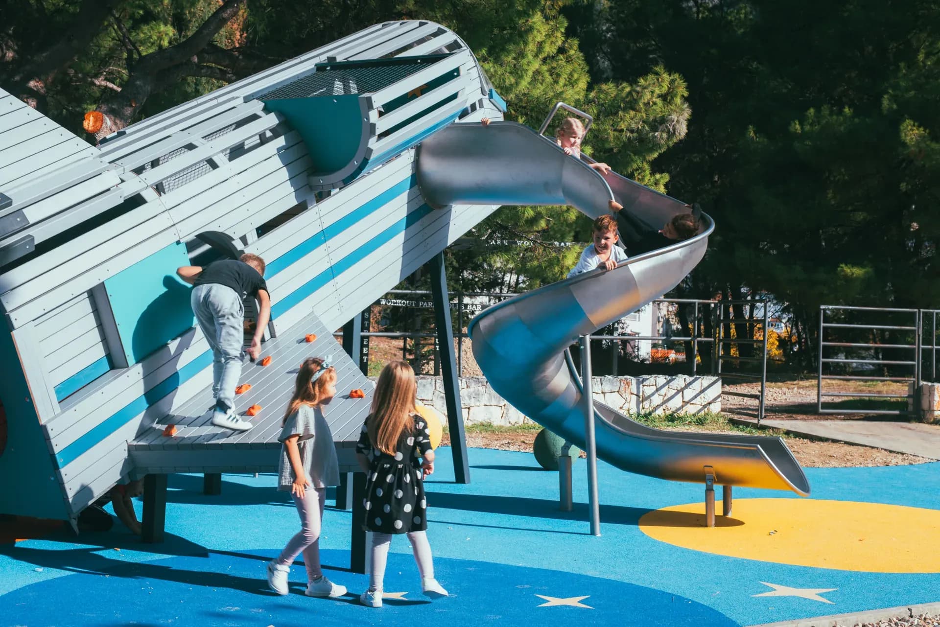 A child climbing the wall of the rocket structure at Makarska Observatory, using coloured holds.