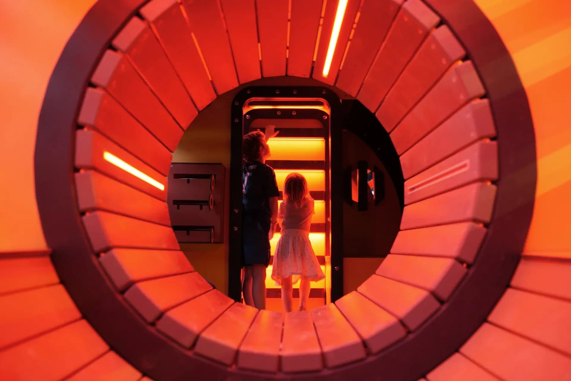 Two children inside the submarine, silhouetted in the passage towards the stairs