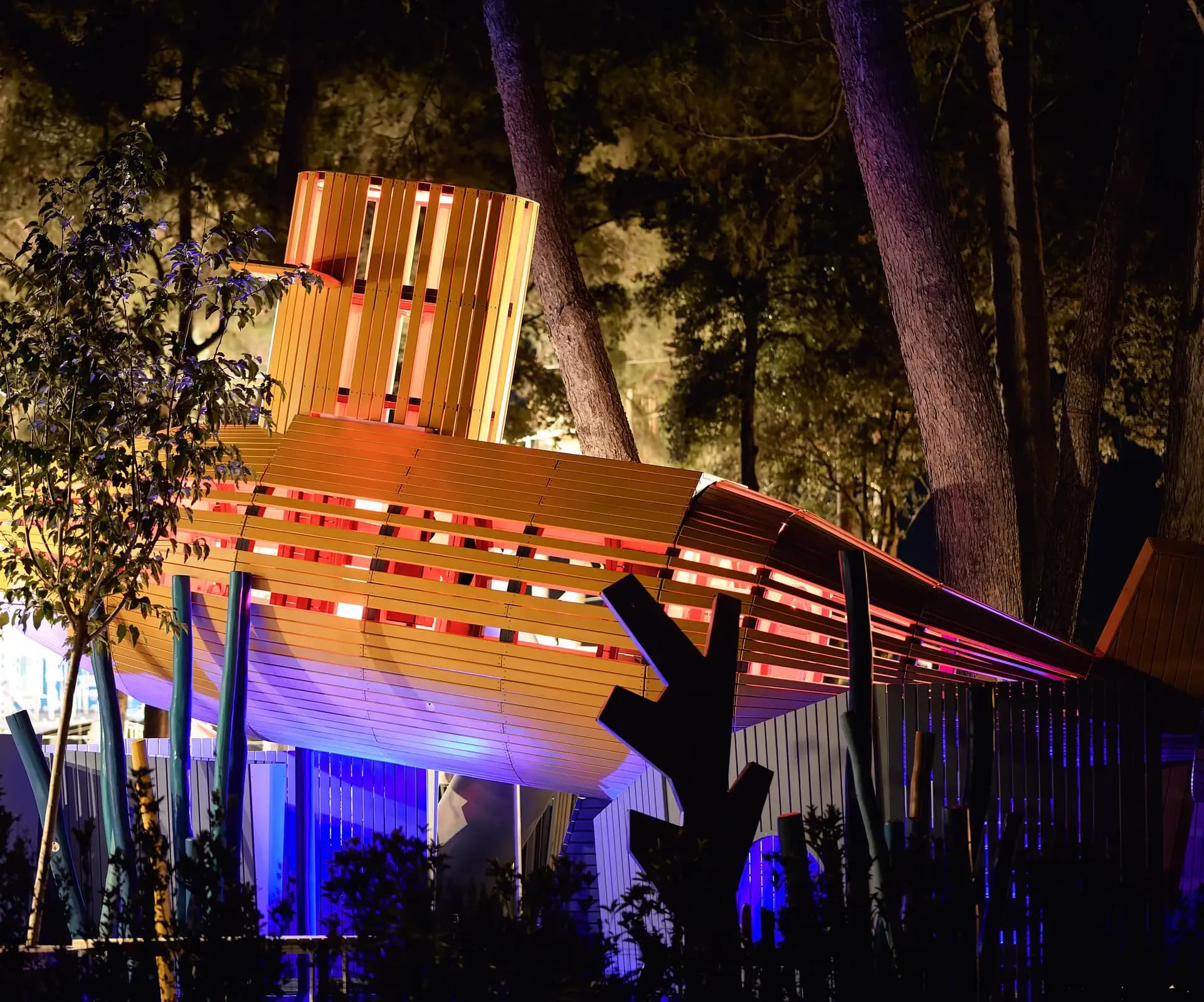 The submarine among the pines in the evening, lit from inside the hull