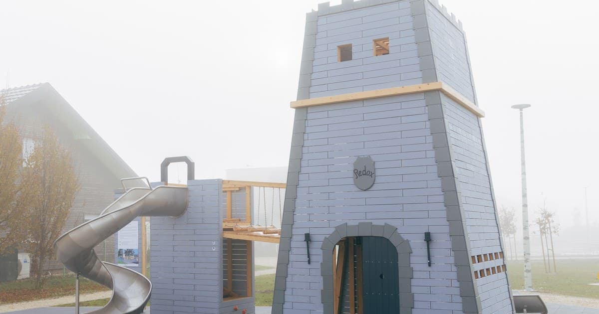 The Timeless Legends castle tower in Prelog, seen against the fog, with its spiral slide and connecting bridge.