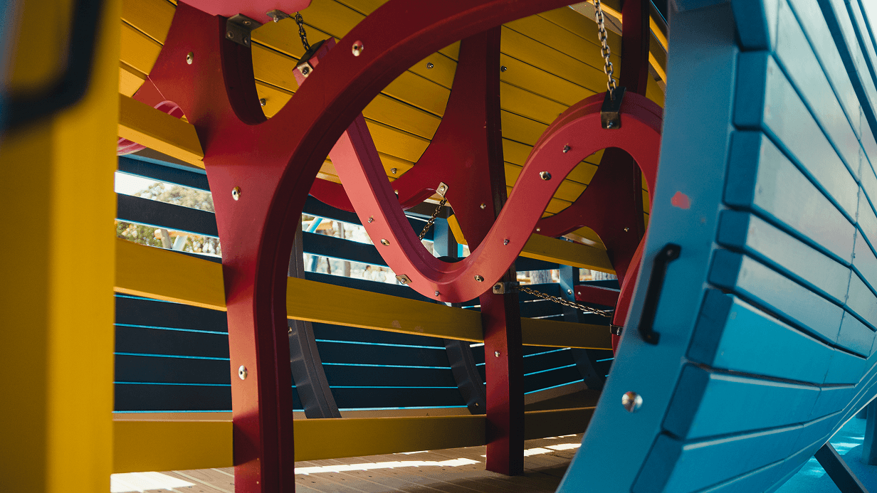 Interior detail of curved structural beams and a connecting walkway inside the play structure at Sea World.