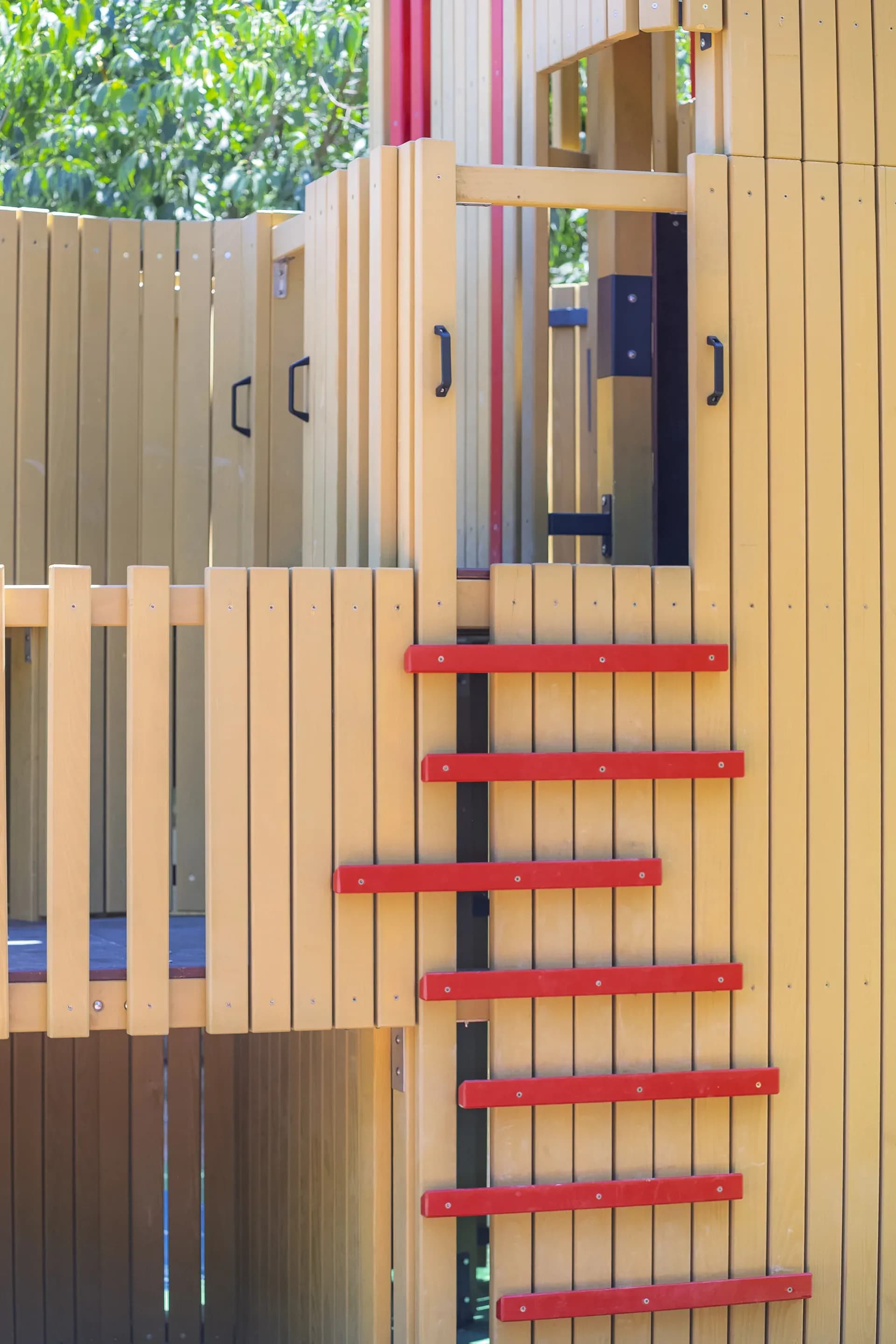 Detail of the vertical timber slats and red ladder rungs on the Urban Structure playground in Trogir.