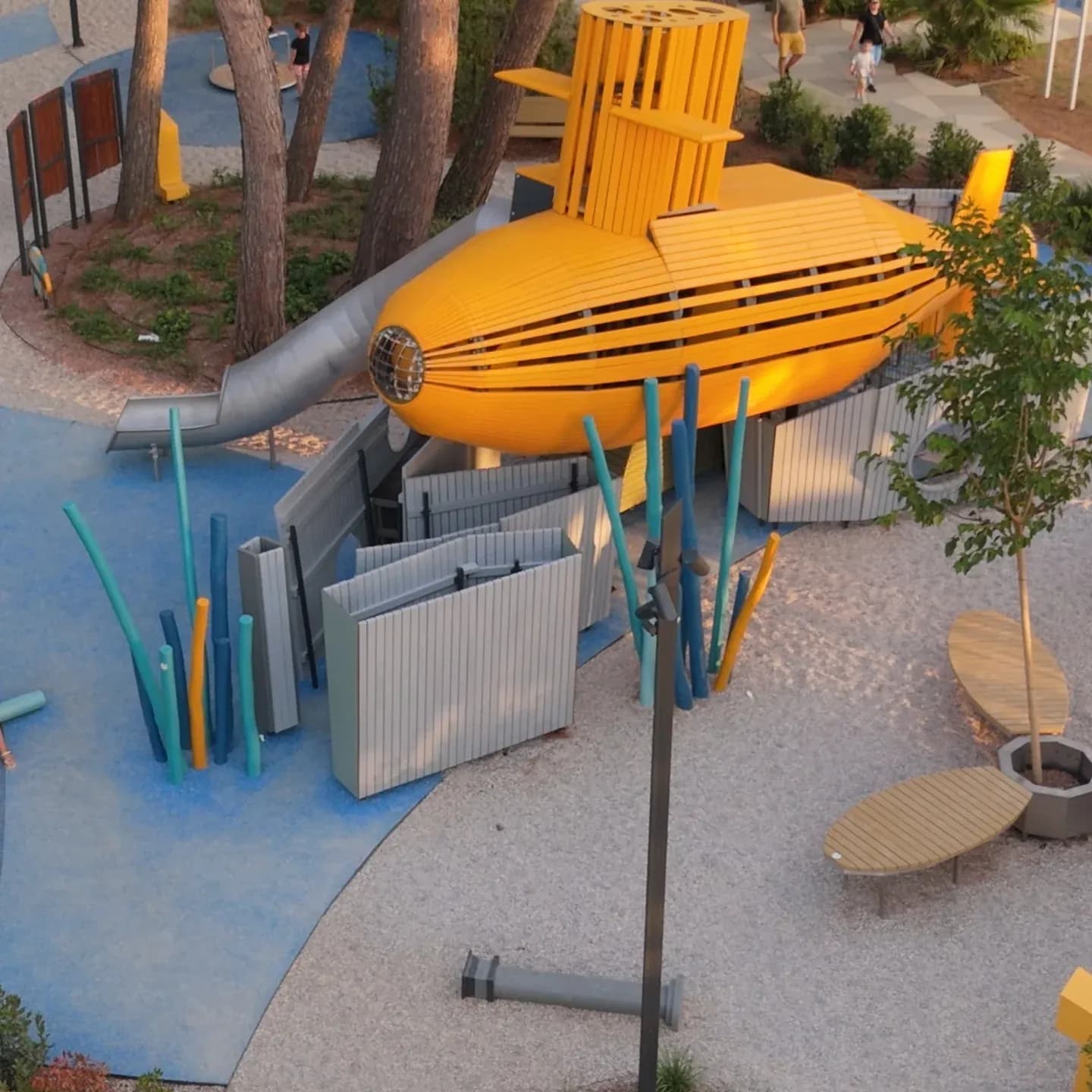 The twelve metre yellow submarine seen in profile from above, with the stainless steel slide and the coloured columns around it, Yellow Submarine playground at Valamar Pical Resort