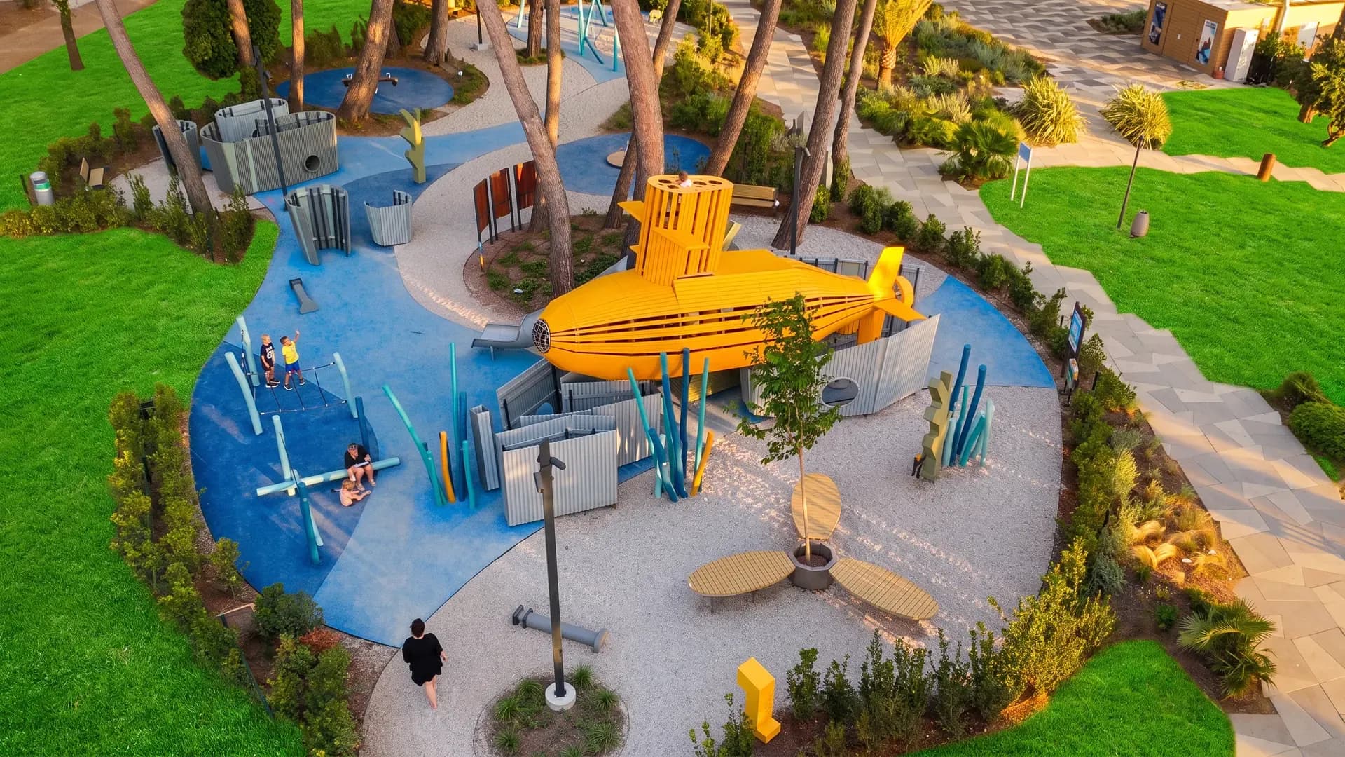 Aerial view of the Yellow Submarine playground complex with the submarine at the centre, the labyrinth walls and the lawn around it, Valamar Pical Resort in Poreč