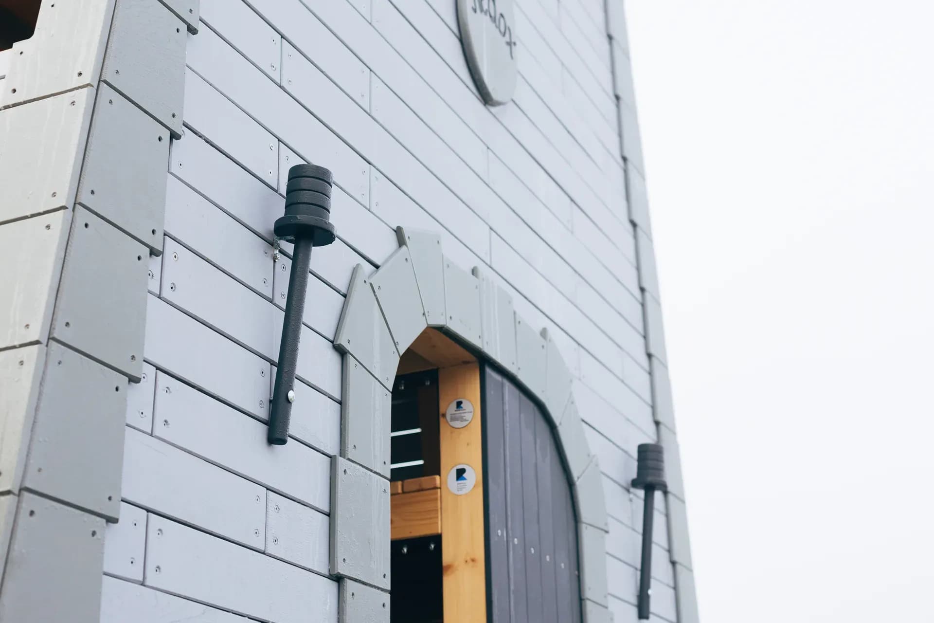 Torch sconces and the arched entrance door of the Timeless Legends tower.