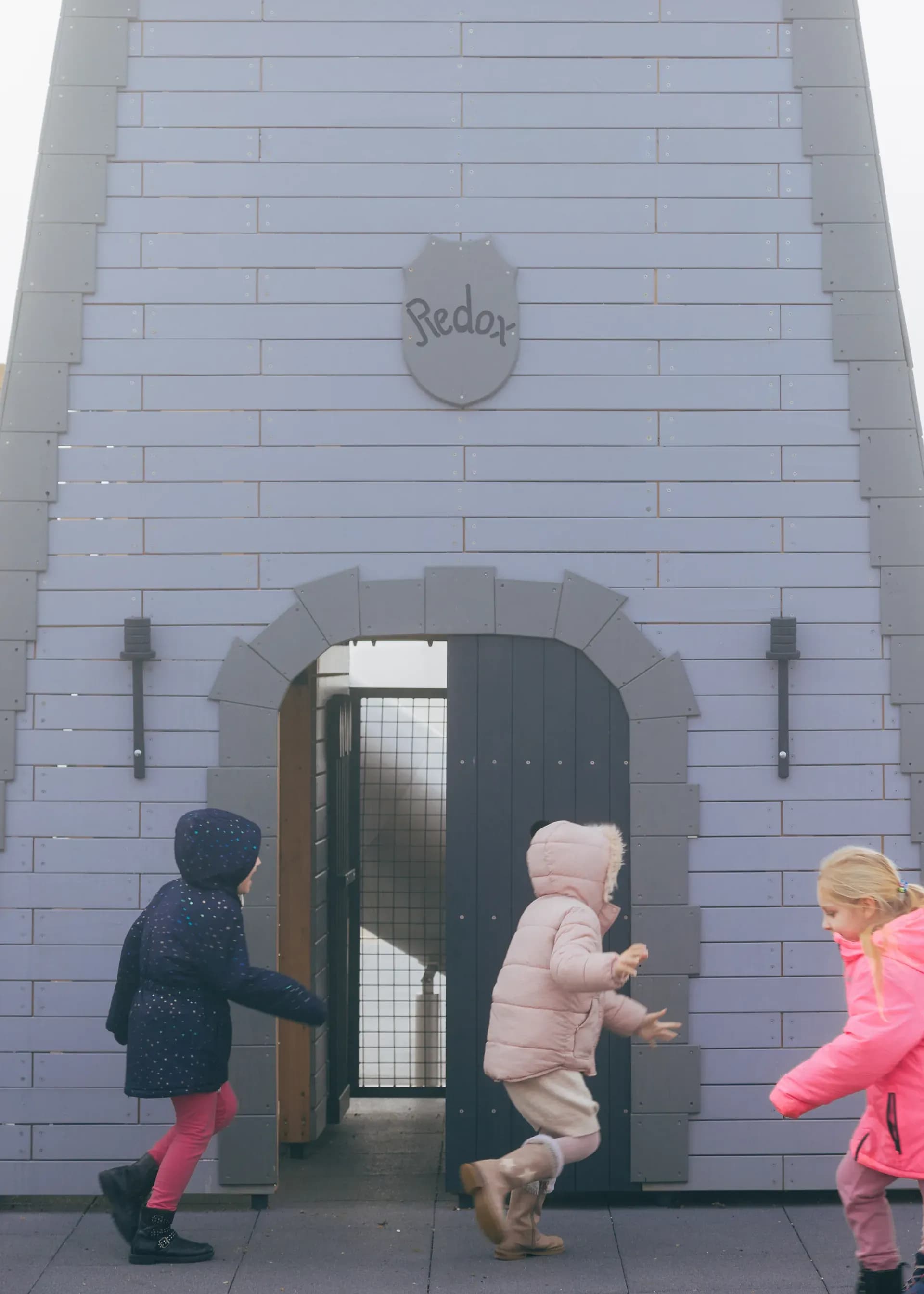 Children running through the tower's arched doorway at Timeless Legends.