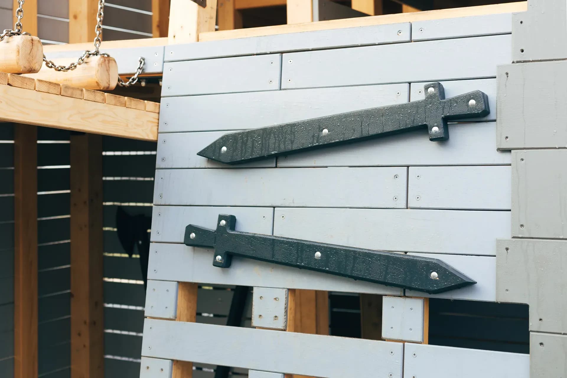 Sword-shaped handles built into the timber cladding of the Timeless Legends tower.